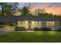 Inviting home with a well-lit front facade, manicured lawn, and attached carport at 313 Ellenwood Dr, Bowdon, GA 30108