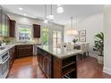 Open kitchen with dark wood cabinets, granite countertops, and stainless steel appliances at 2808 Broughton Se Ln, Atlanta, GA 30339