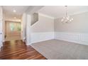 Elegant dining room with carpet, wainscoting detail, crown molding, and a modern chandelier at 362 Lanier Ct, Hiram, GA 30141