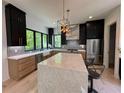 Modern kitchen with black cabinets, a large marble island, stainless steel appliances, and a stylish backsplash at 3960 Clairmont Rd # 2, Chamblee, GA 30341