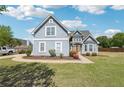 Two-story home with blue exterior, landscaped front yard, and a spacious driveway on a sunny day at 1650 Willow River Run, Grayson, GA 30017