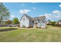Lovely two-story blue home with manicured lawn, driveway, and beautiful blue sky at 1650 Willow River Run, Grayson, GA 30017