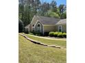Charming one-story home featuring manicured lawn, lush shrubbery, and elegant arched windows at 220 Rehobeth Way, Fayetteville, GA 30214