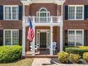 Detailed front porch with an American flag, white columns and charming outdoor seating at 3531 Vintage Trl, Woodstock, GA 30189