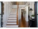 Elegant foyer featuring a staircase, wood floors, and paneled walls at 3825 Raeburn Rd, Cumming, GA 30028