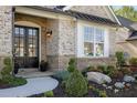 Inviting front porch with stone accents, double doors and manicured landscaping at 3825 Raeburn Rd, Cumming, GA 30028