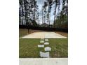 Fenced backyard featuring a basketball court and a stepping stone pathway across the yard at 5617 Casa Blanca Ln, Atlanta, GA 30331