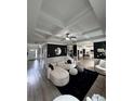 Open-concept living room with hardwood floors, coffered ceilings, and a striking black accent wall at 5617 Casa Blanca Ln, Atlanta, GA 30331
