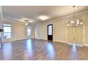 Open living space with hardwood floors, large windows, and a modern chandelier at 504 Otwell Ave, Cumming, GA 30040
