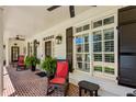 Inviting covered front porch with brick flooring, rocking chairs, and stylish black shutters and exterior lighting at 155 Palmer Oaks Ln, Marietta, GA 30068