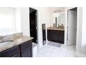 Bathroom featuring double vanity with granite countertop and white tile floors at 309 Daffodil Dr, Temple, GA 30179