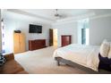 Spacious main bedroom with tray ceiling, carpet, and neutral colors with sitting area at 309 Daffodil Dr, Temple, GA 30179