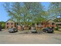 Apartment building with brick facade, mature trees and ample parking in front at 3105 Colonial Way # F, Atlanta, GA 30341
