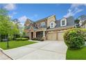 Charming two-story brick home featuring a well-manicured lawn, driveway and attached two car garage at 3597 Old Maple Rd, Johns Creek, GA 30022