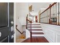 Inviting foyer with hardwood floors, a staircase, and elegant wrought iron railing at 4899 Seldon Se Way, Smyrna, GA 30080