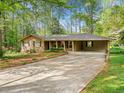 Charming single-story brick home with a long driveway, carport, and beautifully landscaped front yard at 1061 Pathfinder Rd, Marietta, GA 30066