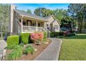 Inviting single-story home with a lovely front porch, manicured garden, and a stone walkway leading to the entrance at 198 Wiley Dr, Douglasville, GA 30134