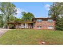 Two-story brick home with a covered carport and quaint front porch, set on a lovely green lawn at 2044 Yucca Dr, Decatur, GA 30032