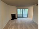Spacious living room has a fireplace, neutral carpet, and sliding glass doors leading to an outdoor patio at 323 Seasons Pkwy, Norcross, GA 30093