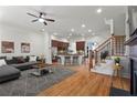 Open-concept living room and kitchen with hardwood floors, a ceiling fan, and a view of the staircase at 2482 Crescent Park Ct, Atlanta, GA 30339