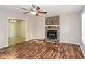 Inviting living room featuring a stone fireplace, ceiling fan, and beautiful wood flooring at 3790 Willow Ridge Rd, Douglasville, GA 30135