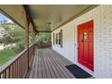 A covered porch with a red front door and a wooden railing at 4973 Gunners Ne Pass, Roswell, GA 30075