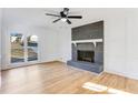 Inviting living room with brick fireplace, light wood floors, lots of natural light, and white trim at 5465 N Fork Sw Dr, Lilburn, GA 30047