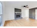 Bright living room featuring a painted brick fireplace, wood flooring, and fresh, neutral paint at 5465 N Fork Sw Dr, Lilburn, GA 30047