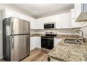 Modern kitchen featuring stainless steel appliances, granite countertops, and white cabinets, offering both style and functionality at 1667 Hollyhock Ter, Decatur, GA 30032