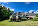 Expansive one-story home featuring a beautifully landscaped yard with flowering shrubs, lush green lawn, and mature trees at 59 Sentry Rdg, Dallas, GA 30157