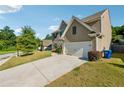 View of the side of the house and driveway with a two-car garage on a sunny day at 7431 St David St, Fairburn, GA 30213