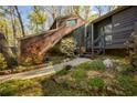 A brown home featuring a unique sloped roof design and a well-maintained garden with blooming flowers at 859 Bridgewater Ct, Stone Mountain, GA 30088
