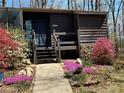 Inviting home exterior featuring a stone foundation and a variety of colorful flowers and shrubbery at 859 Bridgewater Ct, Stone Mountain, GA 30088