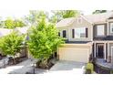 Charming townhome with an attached garage, neutral colors, and a well-maintained landscaped yard with flowering plants at 1058 Mays Sw Hl, Atlanta, GA 30336