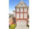 Exterior view of a brick townhouse with a two-car garage and a classic architectural design at 195 Mystic Ct, Atlanta, GA 30342