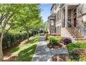 Well-manicured exterior with a sidewalk leading to townhomes, showcasing appealing curb appeal and landscaping at 1012 E Paces Chase, Atlanta, GA 30326