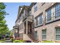Brick townhouse exterior featuring a covered entrance, decorative iron railings, and landscaped walkway at 1012 E Paces Chase, Atlanta, GA 30326