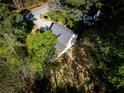 Aerial shot of a house surrounded by dense trees, showcasing its secluded location near a quiet road at 3088 Mount Tabor Church Rd, Dallas, GA 30157