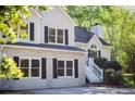 Close-up of a house with stone details, black shutters, and a white staircase leading to the entrance at 3088 Mount Tabor Church Rd, Dallas, GA 30157