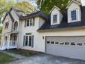Two-story home featuring neutral siding, gray shutters, a two-car garage, and a well-manicured lawn at 311 Indus Ln, Lawrenceville, GA 30044