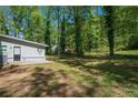 A view of the flat backyard area, surrounded by mature trees, offers privacy and space at 5844 Earlwane Dr, Lithonia, GA 30058