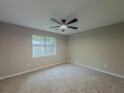 Bedroom featuring plush carpeting, a ceiling fan, and a window to the backyard at 175 Stoneview Cir, Covington, GA 30016