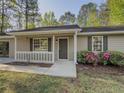 Inviting front porch with white railings and blooming pink azalea bushes at 175 Stoneview Cir, Covington, GA 30016