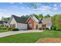 Well-maintained home with a two-car garage, brick accents, and a lush green lawn at 2265 Pemberton Pt, Buford, GA 30519