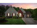 Charming home featuring a manicured lawn, red shutters, and a brick accent wall at sunset at 2265 Pemberton Pt, Buford, GA 30519