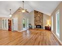 Spacious living room with vaulted ceilings, wood floors, and a stone fireplace at 30 Sweetwood Ct, Roswell, GA 30076