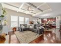Open concept living room with kitchen view, coffered ceilings, and hardwood floors at 4015 Two Bridge Ct, Buford, GA 30518