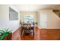Elegant dining room with hardwood floors, stylish chandelier, and ample natural light at 6884 Barker Station Walk, Sugar Hill, GA 30518