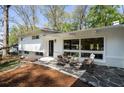 Outdoor patio features stylish seating, stone pavers, and a view of the landscaped yard at 1690 Cotswold Ne Dr, Brookhaven, GA 30319