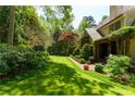Expansive backyard featuring lush green lawn, mature trees, and a covered patio at 2167 W Wesley Nw Rd, Atlanta, GA 30327